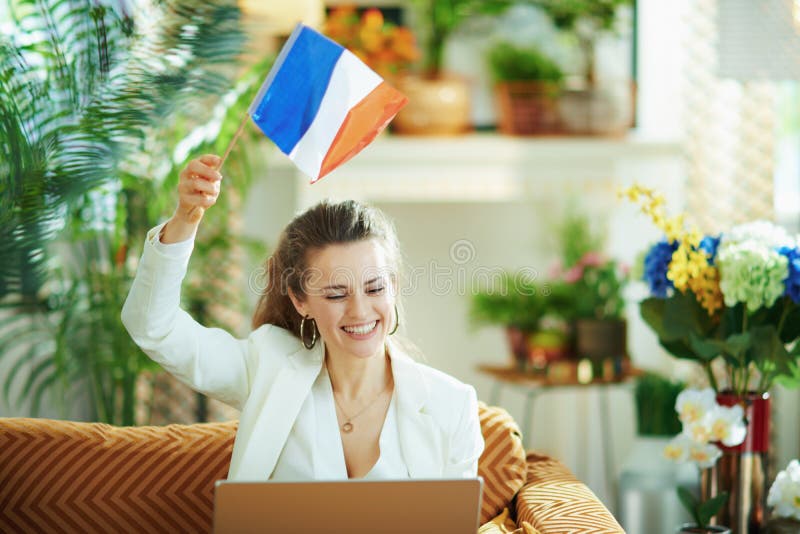 Gelukkige vrouw met laptop en franse vlag leert vreemde taal