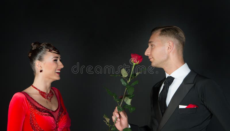 Gelukkige vrouw in rode kleding en man met roze bloem royalty-vrije stock afbeelding Gelukkige vrouw in rode kleding en man met roze bloem royalty-vrije stock afbeelding