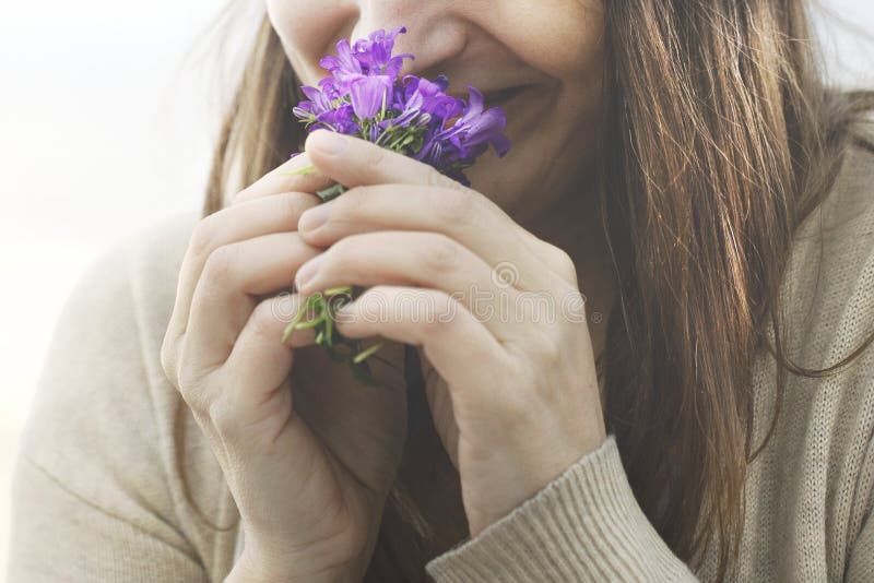 Gelukkige vrouw sluipt een kleine boeket bloemen lente