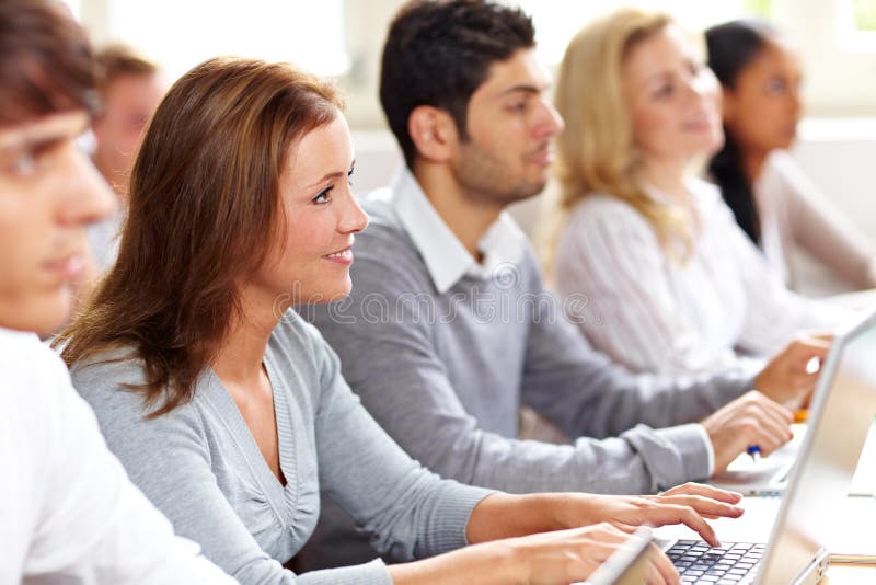 Happy female student with computer in university class. Happy female student with computer in university class