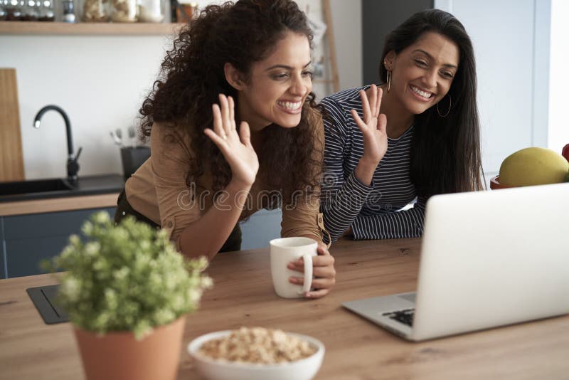 Happy women waving during a video conference at home. Happy women waving during a video conference at home