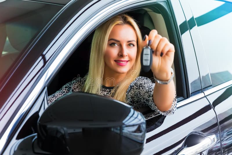 Gelukkige vrouwenbestuurder die autosleutels in haar auto houden stock afbeelding Gelukkige vrouwenbestuurder die autosleutels in haar auto houden stock afbeelding