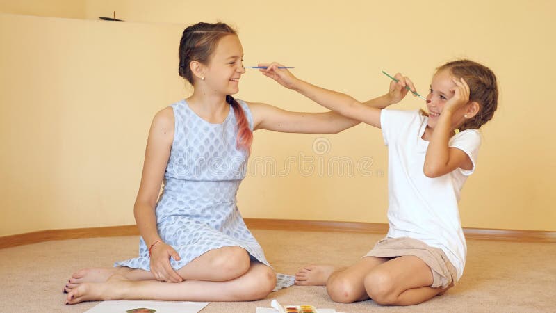 Gelukkige zusters die met penselen spelen