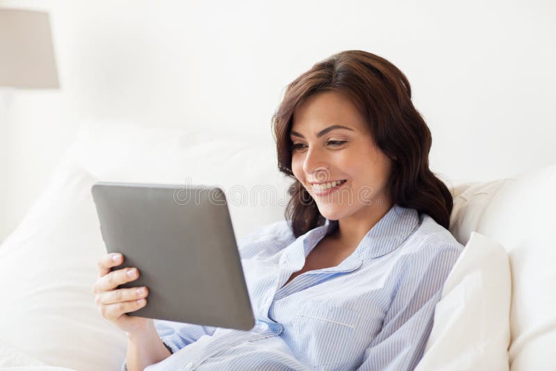 Gelukkige zwangere vrouw met tabletpc thuis royalty-vrije stock foto Gelukkige zwangere vrouw met tabletpc thuis royalty-vrije stock foto