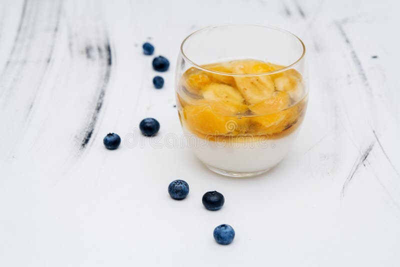 Gelée de fruit colorée dans un verre sur un fond blanc avec des myrtilles image libre de droits Gelée de fruit colorée dans un verre sur un fond blanc avec des myrtilles image libre de droits