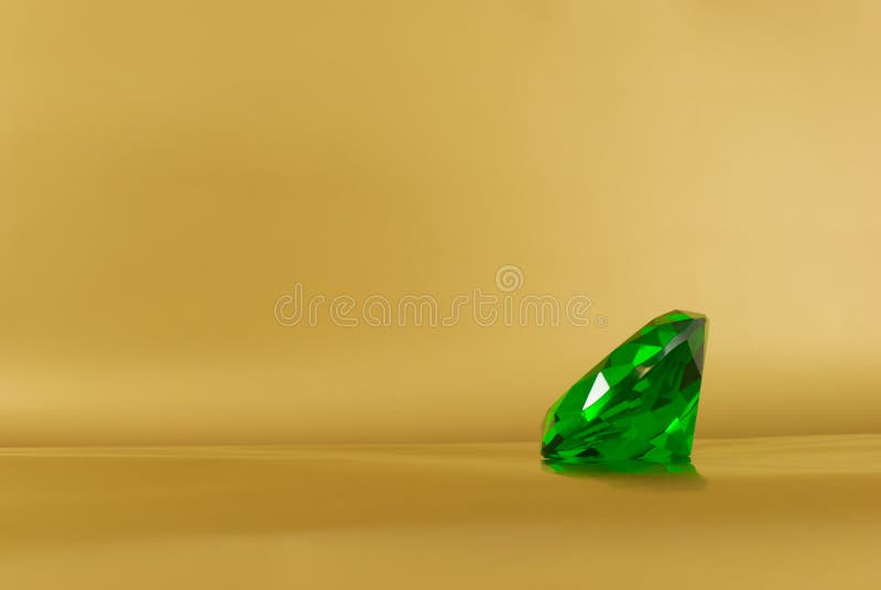 Pedra preciosa verde sobre fundo dourado foto de stock royalty free