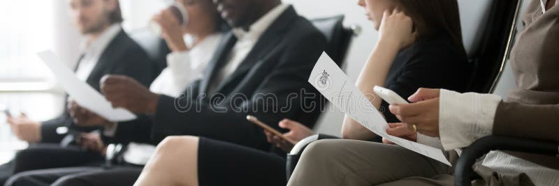 Gemischtrassige Leute des horizontalen Seitenfotos, die in Reihenwarteinterview sitzen lizenzfreie stockfotografie