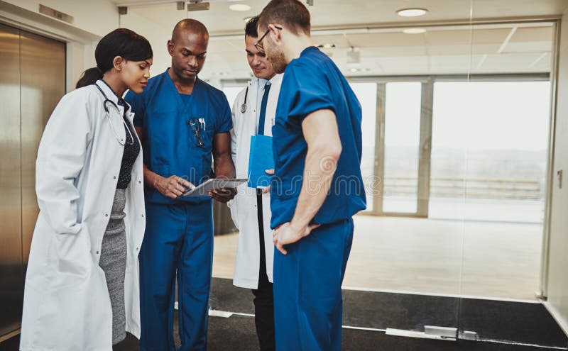 Gemischtrassiges Team von Doktoren, die einen Patienten besprechen lizenzfreie stockbilder Gemischtrassiges Team von Doktoren, die einen Patienten besprechen lizenzfreie stockbilder