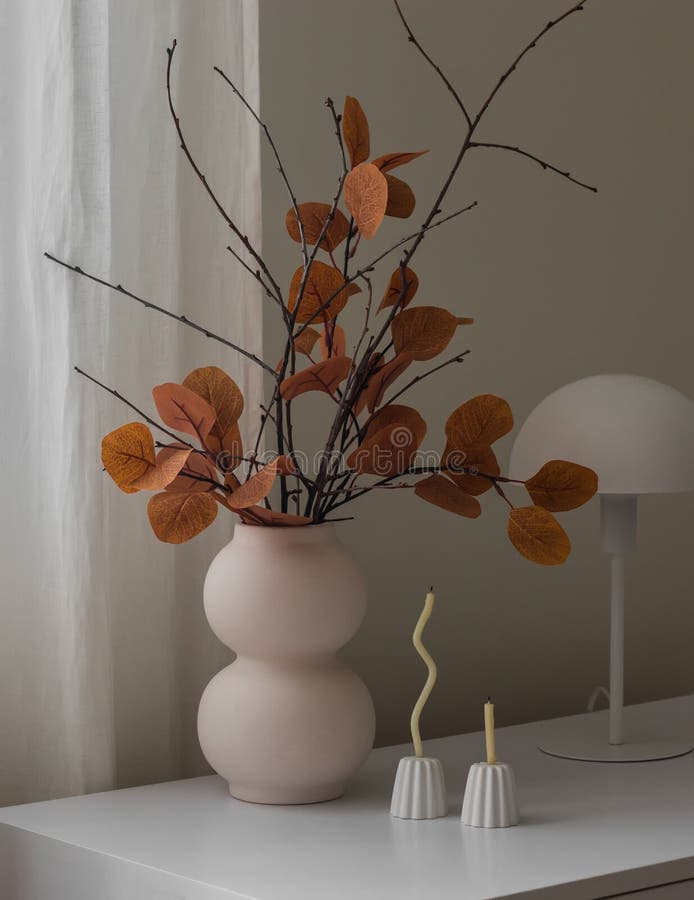 Gemütliche Herbstdekoration mit einem Strauß aus Herbstblättern und Ästen dünne Kerzen in einer Kerze, die eine Tischlampe auf dem lizenzfreie stockfotos