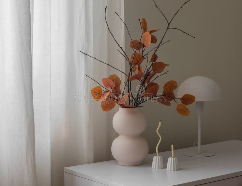 Gemütliche Herbstdekoration mit einem Strauß aus Herbstblättern und Ästen dünne Kerzen in einem Kerzenhalter eine Tischlampe auf d lizenzfreies stockbild