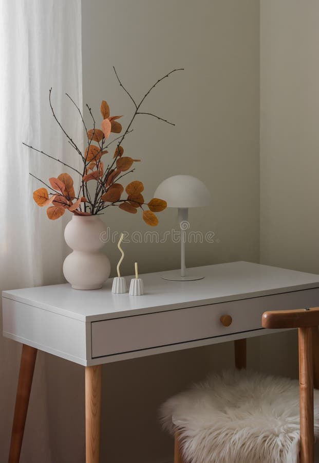 Gemütliche Herbstdekoration mit einem Strauß aus Herbstblättern und Ästen dünne Kerzen in einem Kerzenhalter eine Tischlampe auf d stockfotos