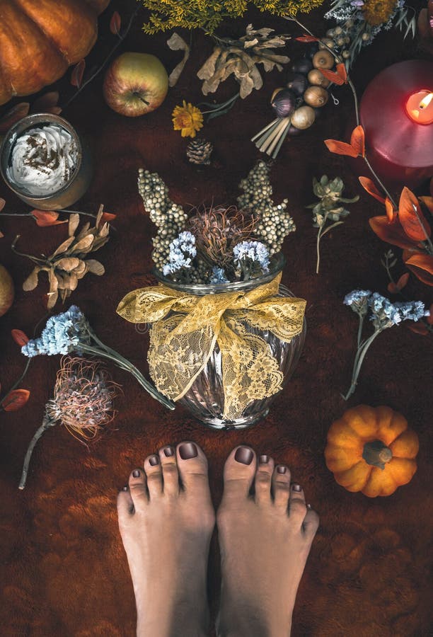 Gemütliche Herbststimmung zu Hause. weibliche Füße und Vase mit Teppichboden mit Trockenblumeanordnung auf Kürbiskerzen und fallen lizenzfreie stockbilder