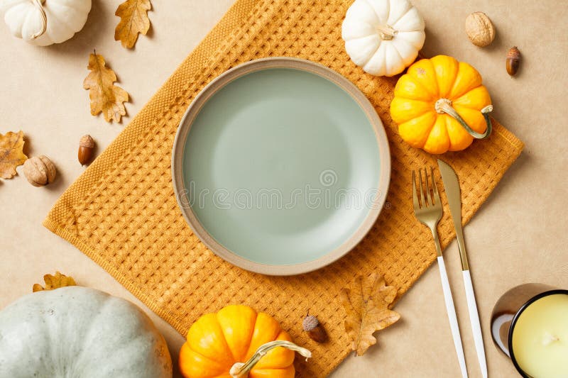 Gemütliche Herbsttischstube mit leeren Tellerkürbissen und Eichenblättern auf beige Hintergrund stockfotos