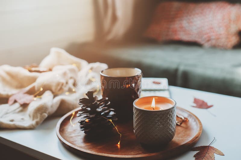 Gemütlicher Herbst- oder Wintermorgen zu Hause Stilllebendetails mit Tasse Tee, Kerze, Skizzenbuch mit Herbarium und warme Strick lizenzfreie stockbilder