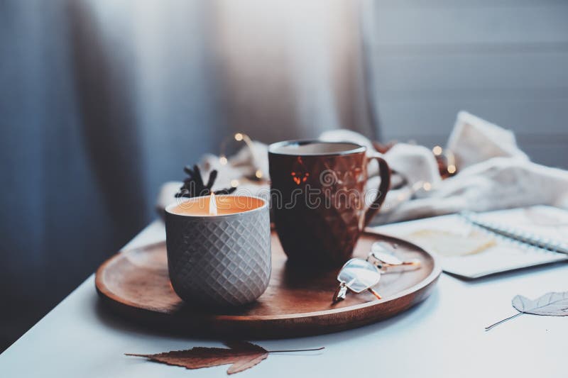 Gemütlicher Herbst- oder Wintermorgen zu Hause Stilllebendetails mit Tasse Tee, Kerze, Skizzenbuch mit Herbarium und warme Strick lizenzfreie stockfotografie