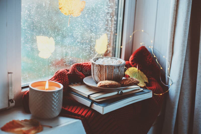 Gemütlicher Herbstmorgen zu Hause Heißer Kakao mit Eibischen und Kerze auf Fenster am regnerischen kalten Tag stockbild