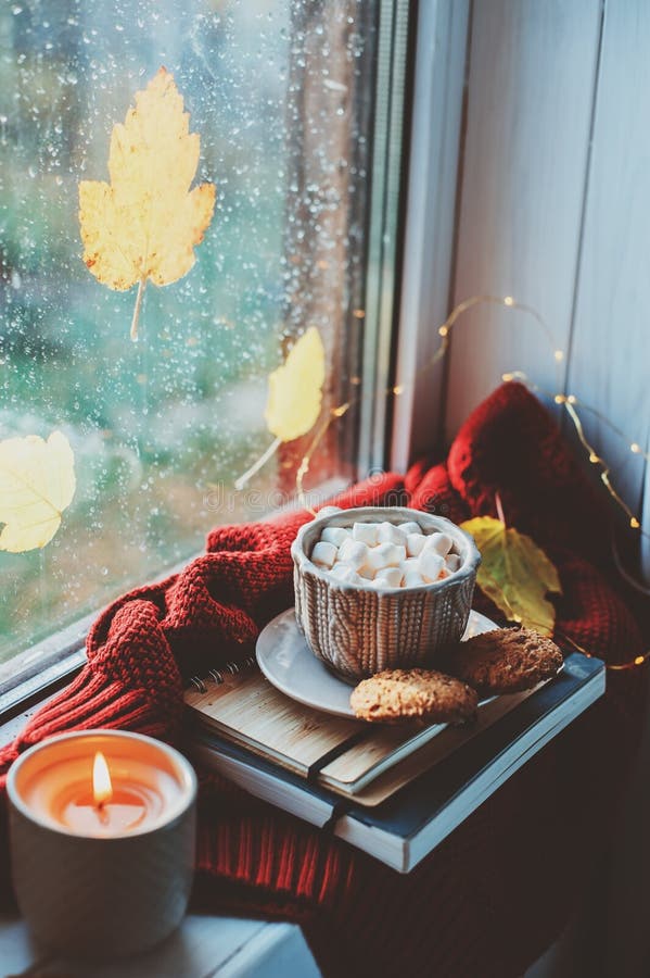 Gemütlicher Herbstmorgen zu Hause Heißer Kakao mit Eibischen und Kerze auf Fenster am regnerischen kalten Tag stockfotografie