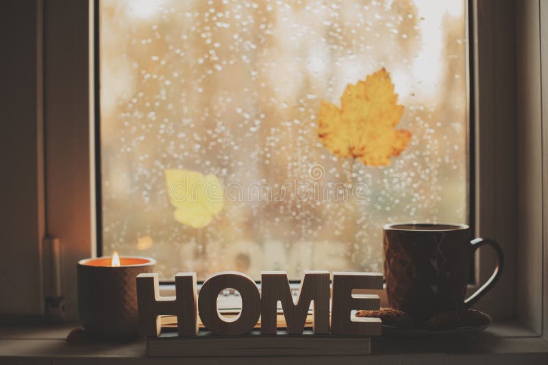Gemütlicher Herbstmorgen zu Hause Heißer Tee und Kerze auf Fenster am regnerischen kalten Tag stockfotografie