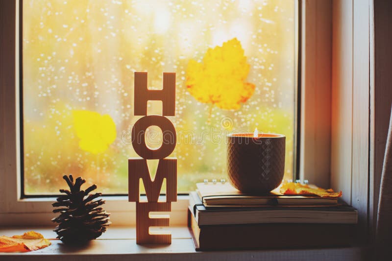 Gemütlicher Herbstmorgen zu Hause Heißer Tee und Kerze auf Fenster am regnerischen kalten Tag stockfoto
