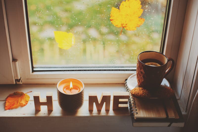Gemütlicher Herbstmorgen zu Hause Heißer Tee und Kerze auf Fenster am regnerischen kalten Tag lizenzfreie stockfotografie