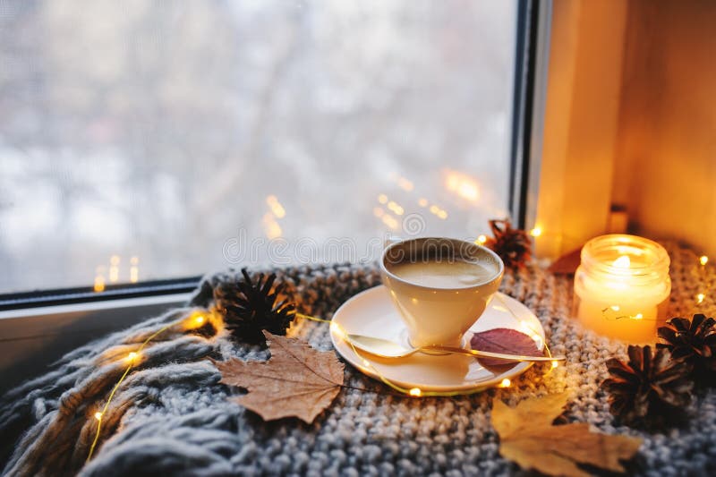 Gemütlicher Winter- oder Herbstmorgen zu Hause Heißer Kaffee mit Goldmetallischem Löffel, warmen Decken-, Girlanden- und Kerzenli lizenzfreie stockfotografie