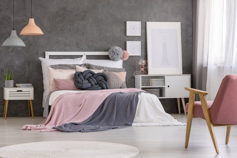 Cozy double bed with many pillows and blankets in a modern, gray and pastel teenage girl bedroom interior. Cozy double bed with many pillows and blankets in a modern, gray and pastel teenage girl bedroom interior