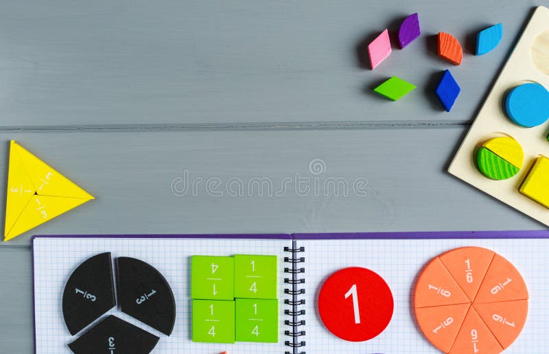 Genau von den mehrfarbigen Mathebrüchen auf dem offenen Editor auf grauem Holztisch. Interessantes Mathematik für Kinderhintergrun lizenzfreies stockfoto