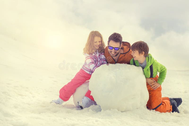 Gene e seus filho e doughter que constroem um boneco de neve fotos de stock