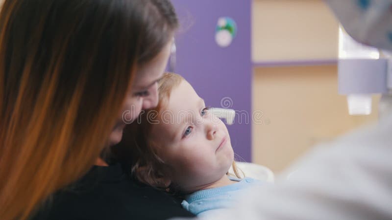 Geneeskunde, tandheelkunde. Een vrouwelijke tandarts onderzoekt de mondholte van een baby stock video