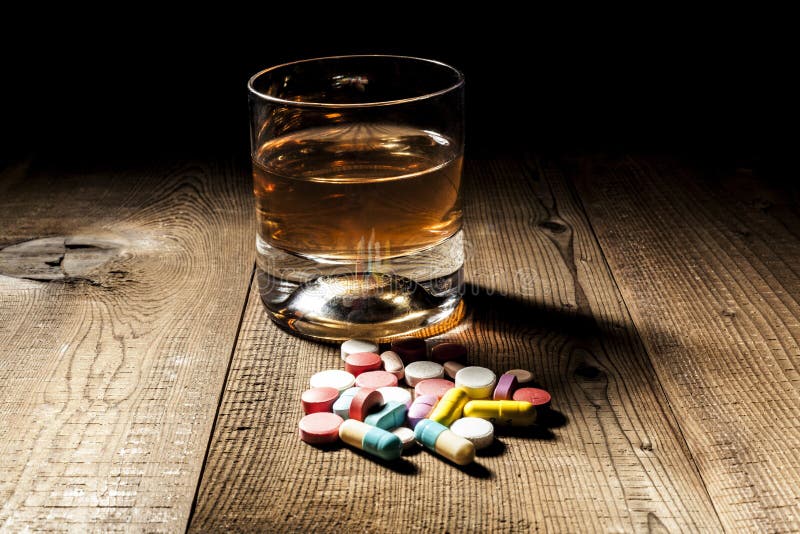 Alcohol and pills with shadow and little black background. Alcohol and pills with shadow and little black background