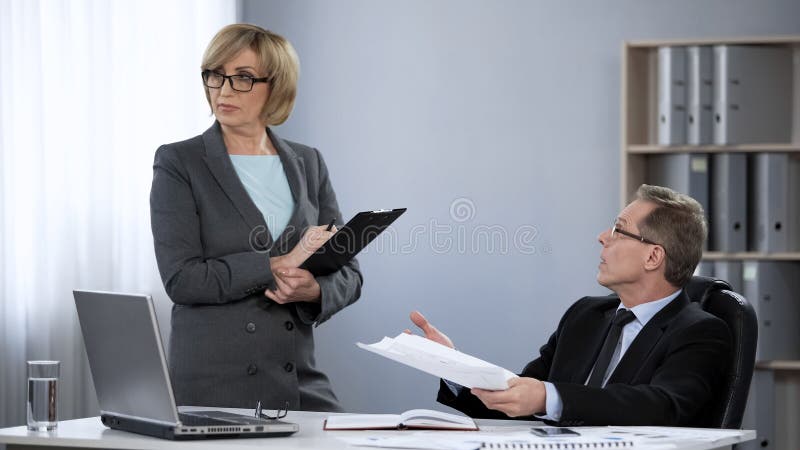 Generaldirektor, der weiblichen Angestellten, stressige Arbeit im Firmenbüro kritisiert lizenzfreies stockbild Generaldirektor, der weiblichen Angestellten, stressige Arbeit im Firmenbüro kritisiert lizenzfreies stockbild