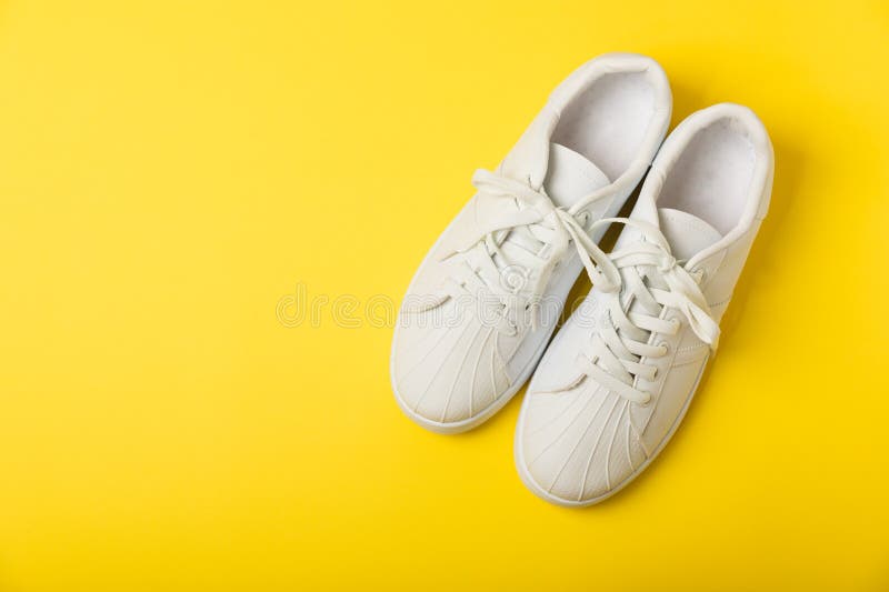 White sneakers, trainers on background. Unisex casual sports shoes. Top view. Space for text. Copy space. Stylish sport shoes. Trendy footwear