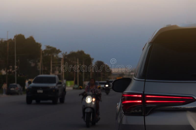 Busy street with rear side of car. Motorcycle and a truck in the background.