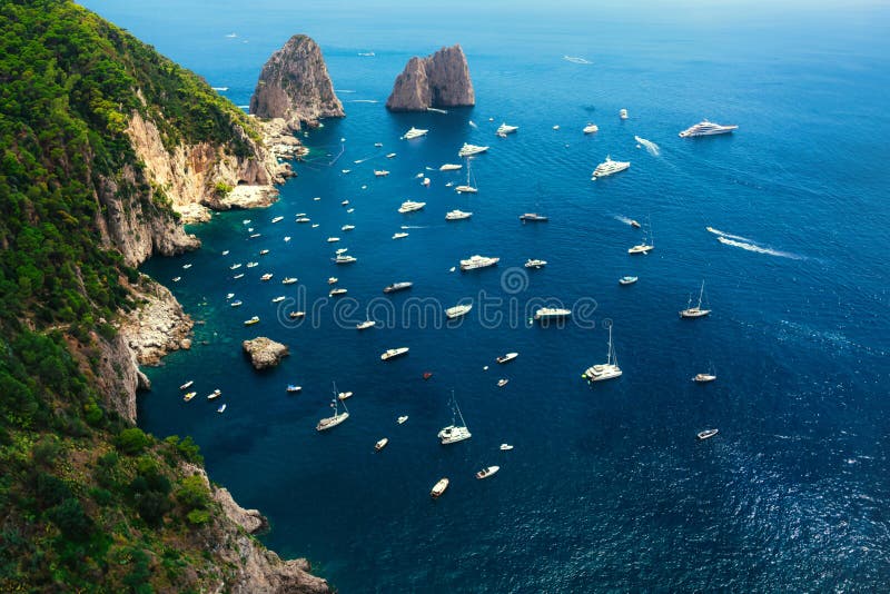 Wide-Angle View of Capriâs Coastline Featuring the Faraglioni Rocks and Boats on Blue Waters