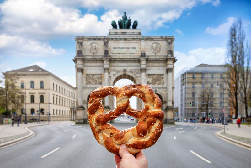 Munich travel concept with a hand holding a traditional german Pretzel