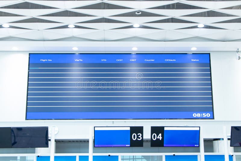 Horizontal empty billboard blue above flight arrival and departure time table check-in counters royalty free stock image