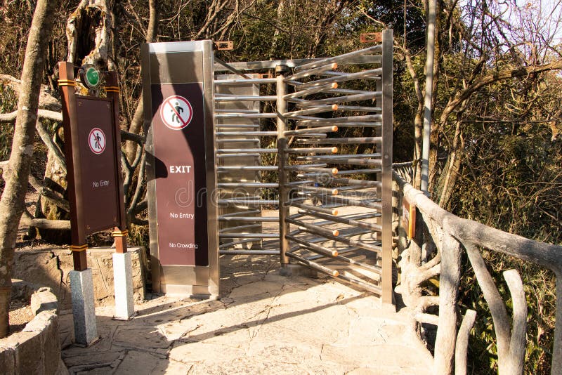 Revolving metal turnstile in interior concrete walkway into the park. royalty free stock photography