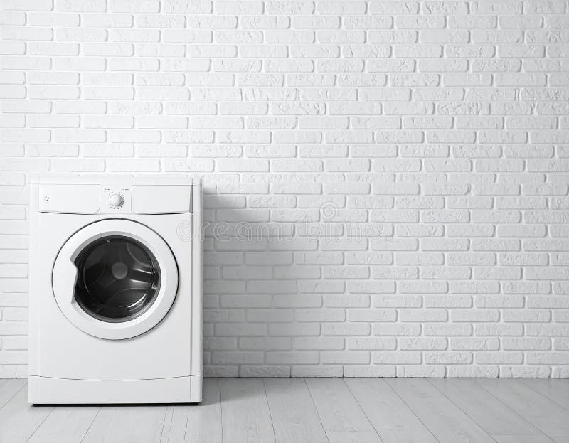 Front-loaded washing machine in a modern laundry room, set against a white brick wall. A potted plant and folded towels sit on top of the machine, adding a touch of greenery and organization. Next to it is a brown woven laundry basket. The area is tiled with neutral-colored flooring, and a striped rug lies in front of the appliances, providing a soft contrast to the sleek and clean design. Modern washing machine near brick wall in empty laundry room. Al Generated. Appliances front illustrations