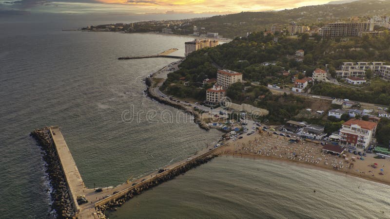 Aerial drone view of beach, pier and coastal hotels at sunset on the Black Sea in Golden Sands resort Bulgaria