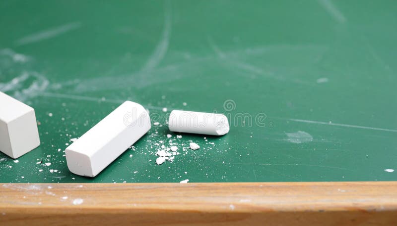 A close-up shot of white chalk pieces and a blackboard eraser on the edge of a well-used green chalkboard. The texture of chalk dust and the worn board surface evokes the atmosphere of classroom learning. Perfect for education, study, and school-related visuals. Ideal as a detail image for academic or teaching-themed designs. Classroom podium illustrations