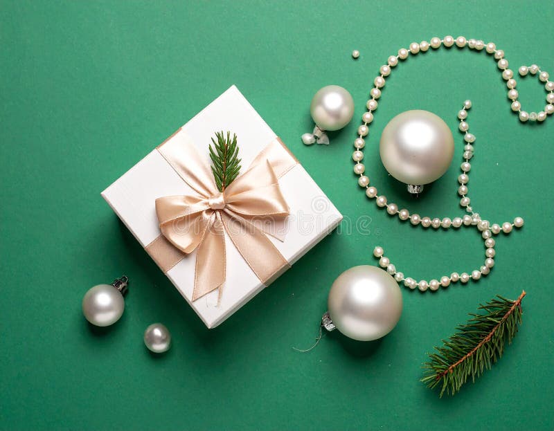 Christmas gift box with elegant pearl jewelry and decorations on a green background. royalty free illustration