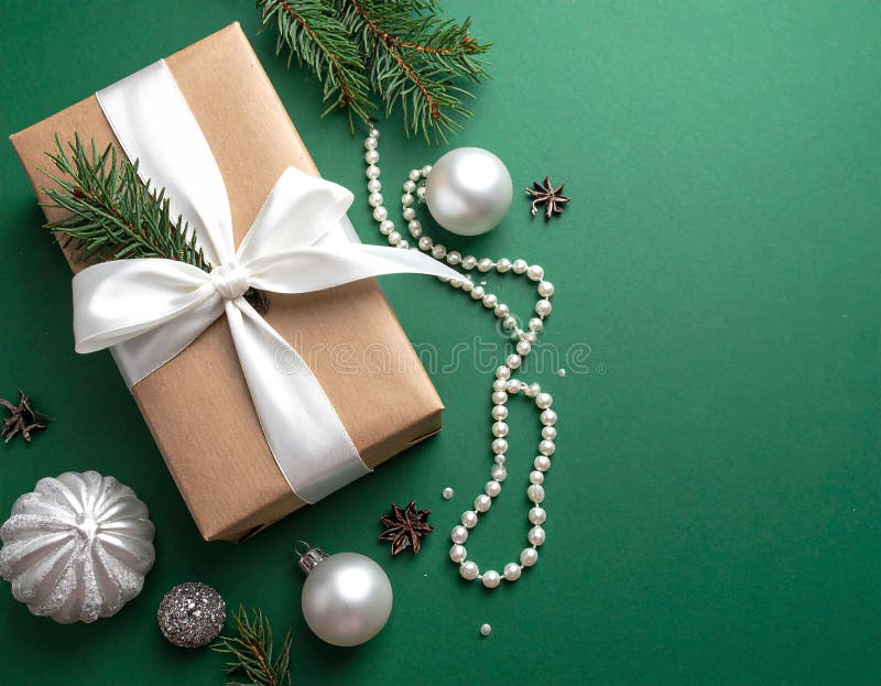 Christmas gift box with elegant pearl jewelry and decorations on a green background. stock illustration