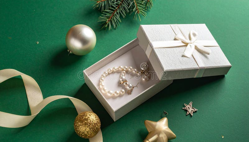 Christmas gift box with elegant pearl jewelry and decorations on a green background. royalty free illustration