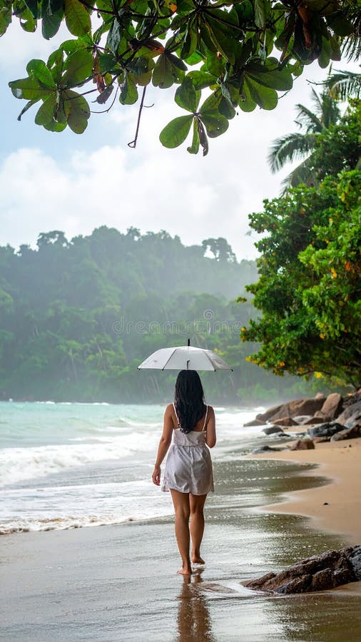 A woman walks along a tropical beach holding a lavender umbrella, wearing short denim shorts and a bikini top. The shoreline curves gently alongside lush green foliage and palm trees, creating a vibrant backdrop. The ocean's waves are visible to the left, and the scene suggests a light rain or mist, contributing to a serene and tranquil atmosphere. The surrounding environment indicates a humid, coastal location with a dense, natural landscape. Back view, Asian woman walking from the ocean into jungle, Thailand. Rainny season. Al Generated. Short denim illustrations