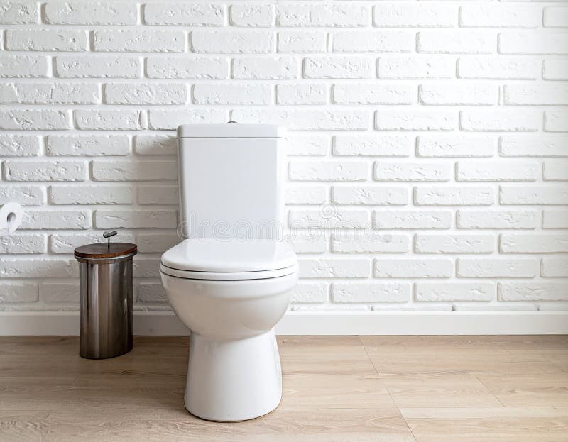 In the restroom, a ceramic toilet next to the white brick wall. royalty free illustration
