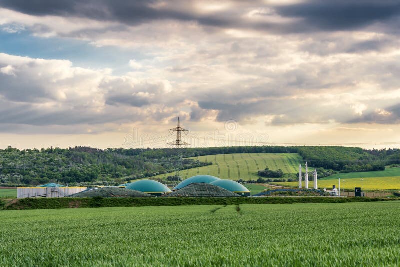 Biomethane plant between fields in rural area at sunset