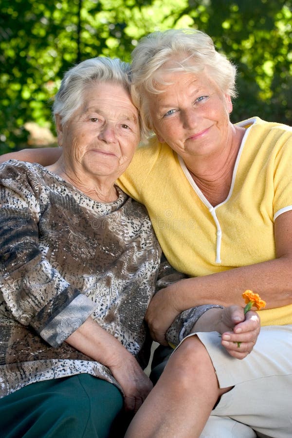 A senior woman with her 60 year old daughter huging each other. Old granny stock images, royalty-free photos and pictures