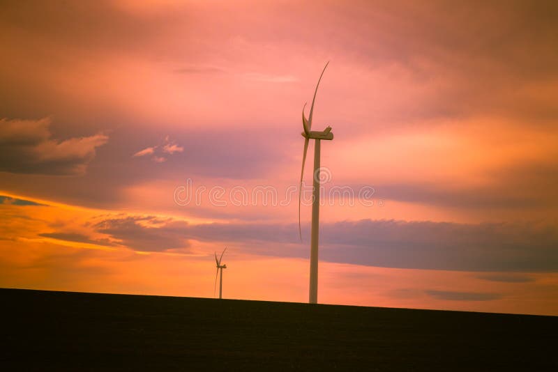 Generatori eolici contro un bello cielo di tramonto fotografia stock Generatori eolici contro un bello cielo di tramonto fotografia stock