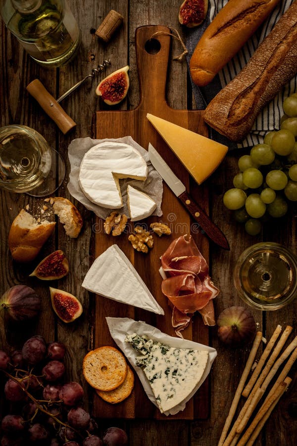 Generi differenti di formaggi, di vino, di baguette, di frutti e di spuntini fotografia stock