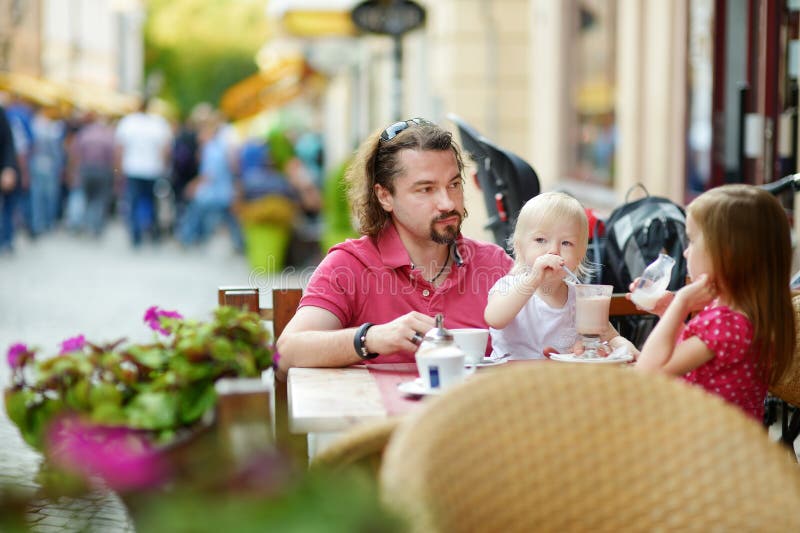 Generi e le sue figlie che si rilassano in caffè all'aperto immagini stock libere da diritti Generi e le sue figlie che si rilassano in caffè all'aperto immagini stock libere da diritti